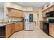 Well-equipped kitchen with stainless steel refrigerator, light-wood cabinets and black appliances at 4427 W Powell Dr, New River, AZ 85087