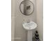 Modern powder room with pedestal sink, round mirror, and stylish decor for a clean, contemporary look at 4656 E Beck Ln, Phoenix, AZ 85032
