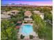 Aerial view of a community pool surrounded by trees, lush landscaping, lounge chairs, and a mountain backdrop at 4656 E Beck Ln, Phoenix, AZ 85032