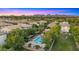 Neighborhood aerial view of the community pool, lush trees and manicured landscaping, set against a colorful sunset at 4656 E Beck Ln, Phoenix, AZ 85032