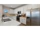 Stylish kitchen with stainless steel appliances, white cabinets, and herringbone backsplash at 4656 E Beck Ln, Phoenix, AZ 85032