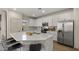 Well-lit kitchen featuring white cabinets, stainless steel appliances, and a spacious island at 4656 E Beck Ln, Phoenix, AZ 85032