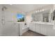 The bright bathroom features double sinks, a glass-enclosed shower and a soaking tub below a window at 4656 E Beck Ln, Phoenix, AZ 85032