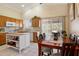 Bright kitchen with an island, wooden cabinets, and an adjoining dining area at 481 S San Marcos Dr, Apache Junction, AZ 85120