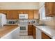 Well-lit kitchen features oak cabinets, white appliances, and a functional layout with a small island at 481 S San Marcos Dr, Apache Junction, AZ 85120