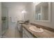 Bright bathroom featuring double sinks with granite counters and a glass enclosed shower at 6707 E Beverly Ln, Scottsdale, AZ 85254