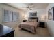 Cozy bedroom featuring a ceiling fan, shuttered windows, and neutral walls at 6707 E Beverly Ln, Scottsdale, AZ 85254