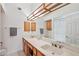 Bathroom featuring dual sinks, spacious mirror, and shower behind a curtain at 6719 W Kerry Ln, Glendale, AZ 85308