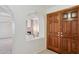 Entryway displaying wood double doors, arched doorway looking into the living room with a stone fireplace at 6719 W Kerry Ln, Glendale, AZ 85308