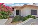 Exterior of home showcasing decorative plants and front entrance with stone pillars and dark wood double doors at 6719 W Kerry Ln, Glendale, AZ 85308