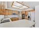 Kitchen with wood cabinets, white countertops, stainless steel appliances and a view of the breakfast bar at 6719 W Kerry Ln, Glendale, AZ 85308