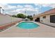 Backyard pool area with a blue pool, concrete surround, privacy wall and outdoor seating and lounge areas at 6719 W Kerry Ln, Glendale, AZ 85308