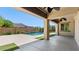 Covered patio overlooks a modern pool with a water feature and manicured landscaping at 6917 E Ingram Cir, Mesa, AZ 85207