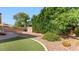 Well-maintained backyard with artificial grass, desert landscaping, and mature trees at 6917 E Ingram Cir, Mesa, AZ 85207