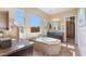 Bright bathroom with dual vanities, soaking tub under large window, neutral tile, and view of walk-in closet at 6917 E Ingram Cir, Mesa, AZ 85207