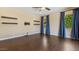 Spacious bedroom featuring wood-look floors, ceiling fan, and dark blue window treatments at 6917 E Ingram Cir, Mesa, AZ 85207