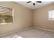 Bedroom with light carpet, window blinds and ceiling fan, offers a comfortable and serene living space at 6917 E Ingram Cir, Mesa, AZ 85207