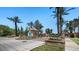A view of the Annecy community entrance with mature trees, desert landscaping, and a guard house at 6917 E Ingram Cir, Mesa, AZ 85207