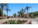 A beautiful Annecy community entrance with lush landscaping, palm trees, and brick-paved drive at 6917 E Ingram Cir, Mesa, AZ 85207