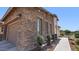 Close-up of the home's exterior with stone accents, well-manicured plants, and a three-car garage at 6917 E Ingram Cir, Mesa, AZ 85207
