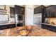 Kitchen island with granite countertop, stainless steel appliances, and dark wood cabinetry at 6917 E Ingram Cir, Mesa, AZ 85207