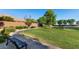 Scenic park with a sidewalk, bench, trees, and green grass at 6917 E Ingram Cir, Mesa, AZ 85207