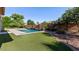Beautiful pool area featuring artificial turf, rock landscaping, and a waterfall feature at 6917 E Ingram Cir, Mesa, AZ 85207