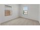 A simple bedroom features neutral carpet and two windows for natural light at 7327 S 76Th Ln, Laveen, AZ 85339