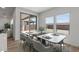 Bright dining area with modern table and chairs, offering serene views through sliding glass doors and windows at 7327 S 76Th Ln, Laveen, AZ 85339