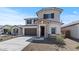 Charming two-story home featuring a stone-accented entrance, dark shutters, and a well-maintained front yard at 7327 S 76Th Ln, Laveen, AZ 85339