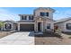 Beautiful home with a two-car garage, stone accents, and neutral exterior paint under a clear blue sky at 7327 S 76Th Ln, Laveen, AZ 85339