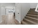Hallway featuring stairs and a glimpse into a bright, open-concept kitchen and living area at 7327 S 76Th Ln, Laveen, AZ 85339