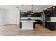 Bright, open-concept kitchen featuring dark cabinets, a white island, and modern stainless steel appliances at 7327 S 76Th Ln, Laveen, AZ 85339