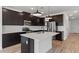 Modern kitchen with dark cabinetry, stainless steel appliances, a center island, and stylish pendant lighting at 7327 S 76Th Ln, Laveen, AZ 85339