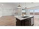 Open kitchen island with sink overlooks bright living area and large windows that offer generous natural light at 7327 S 76Th Ln, Laveen, AZ 85339
