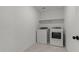 Compact laundry room equipped with modern appliances and a convenient overhead shelf at 7327 S 76Th Ln, Laveen, AZ 85339