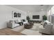 Stylish living room with neutral decor, plush seating, and a large television for a comfortable living space at 7327 S 76Th Ln, Laveen, AZ 85339