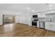 View of kitchen with stainless appliances, and light-filled living area and balcony at 7920 E Camelback Rd # 104, Scottsdale, AZ 85251