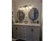 Bathroom vanity with dual sinks, elegant mirrors, and neutral decor at 8879 E Friess Dr, Scottsdale, AZ 85260