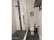 Modern walk-in shower with rainfall showerhead, black fixtures, and tiled shower with shelving at 8879 E Friess Dr, Scottsdale, AZ 85260