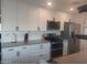 A modern kitchen featuring white cabinets, stainless steel appliances, and light countertops at 8879 E Friess Dr, Scottsdale, AZ 85260