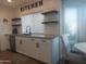 Modern kitchen with white cabinets, quartz countertops, stainless steel appliances, and open shelving, great for cooking at 8879 E Friess Dr, Scottsdale, AZ 85260