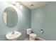 Cozy powder room features a pedestal sink, round mirror, and tile flooring at 931 S Racine Ln, Gilbert, AZ 85296