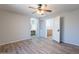 An airy bedroom featuring wood-look flooring, neutral walls, and open doorway to bathroom area at 931 S Racine Ln, Gilbert, AZ 85296