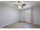 Bedroom featuring wood-look floors, one window with pink curtains, and a ceiling fan at 931 S Racine Ln, Gilbert, AZ 85296