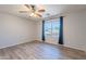 Bright bedroom with a ceiling fan, wood-look floors, and a large window with curtains, inviting natural light at 931 S Racine Ln, Gilbert, AZ 85296