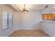 Dining area with chandelier lighting, tile floors, and a window overlooking the backyard offers natural light at 931 S Racine Ln, Gilbert, AZ 85296