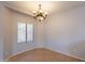 Charming dining space features tile flooring, a bright window, and chandelier providing a cozy ambiance at 931 S Racine Ln, Gilbert, AZ 85296
