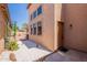 Back side of home with desert landscaping, view of multiple windows and a side door at 931 S Racine Ln, Gilbert, AZ 85296