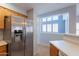 Bright kitchen with stainless steel refrigerator and a unique window offers natural light and modern style at 931 S Racine Ln, Gilbert, AZ 85296